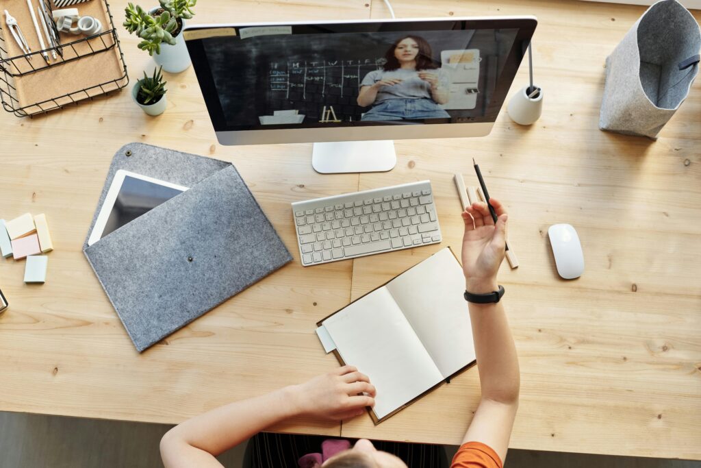 Tutoriales Teen girl actively learning in an organized home workspace via online class on a desktop computer.